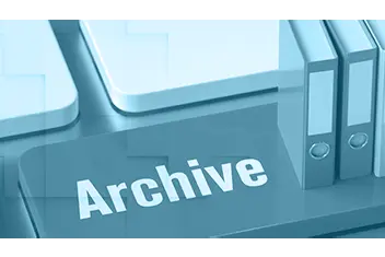 Miniatur-Aktenordner auf einer Computer-Tastatur mit dem Schriftzug "Archive".