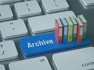 Miniatur-Aktenordner auf einer Computer-Tastatur mit dem Schriftzug "Archive".