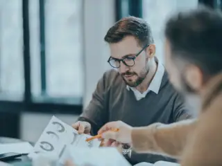Two men in finance work with AI.