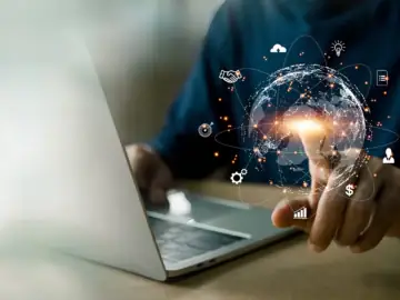 Ein Mann hält eine virtuelle Erdkugel, um die digitale Symbole schwirren, die für die Cloud, für digitale Dokumente, digitales Bezahlen und vieles mehr stehen.