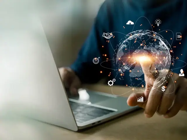 Ein Mann hält eine virtuelle Erdkugel, um die digitale Symbole schwirren, die für die Cloud, für digitale Dokumente, digitales Bezahlen und vieles mehr stehen.