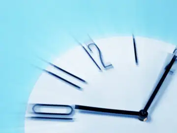 Das etwas verschwommene Ziffernblatt einer Uhr, die 10 Uhr und 5 Minuten anzeigt.