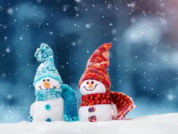 Zwei lächelnde Schneemänner mit Strickmütze und Schal.