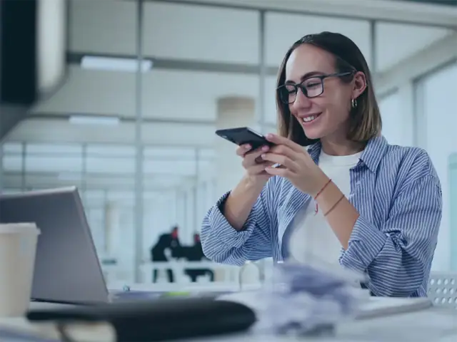 Frau fotografiert ein Dokument mit dem Handy.