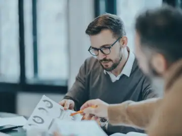 Two men in finance work with AI.