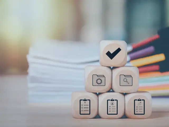 Mehrere Würfel mit Symbolen, die für Compliance-Regeln im Unternehmen stehen.